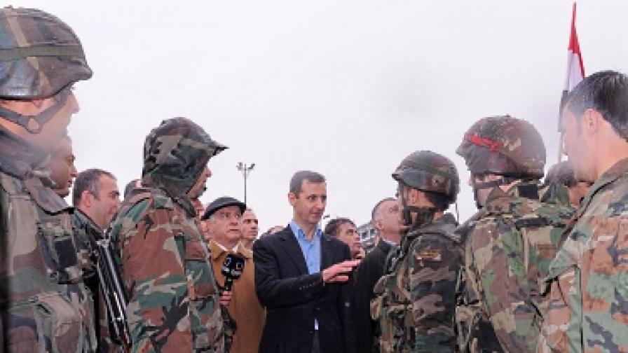 Асад разговаря с войници при обиколката си на квартал Баба Амр в Хомс. Кварталът беше крепост на бунтовниците, докато не беше смазан от армията в началото на март