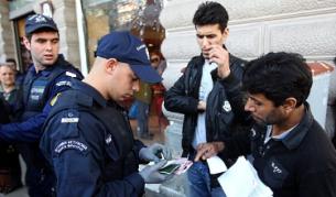 Гръцки полицаи проверяват документите за самоличност на имигранти в Атина