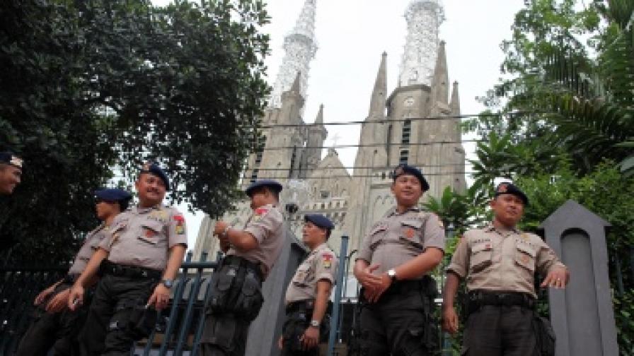 Индонезийски полицаи охраняват католическа катедрала в Джакарта по време на рождественската служба