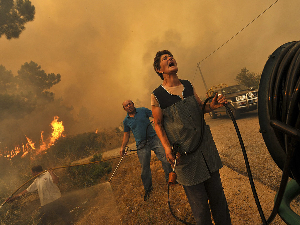 Местни хора се борят с горски пожар близо до Визеу, Португалия, на 11 август.