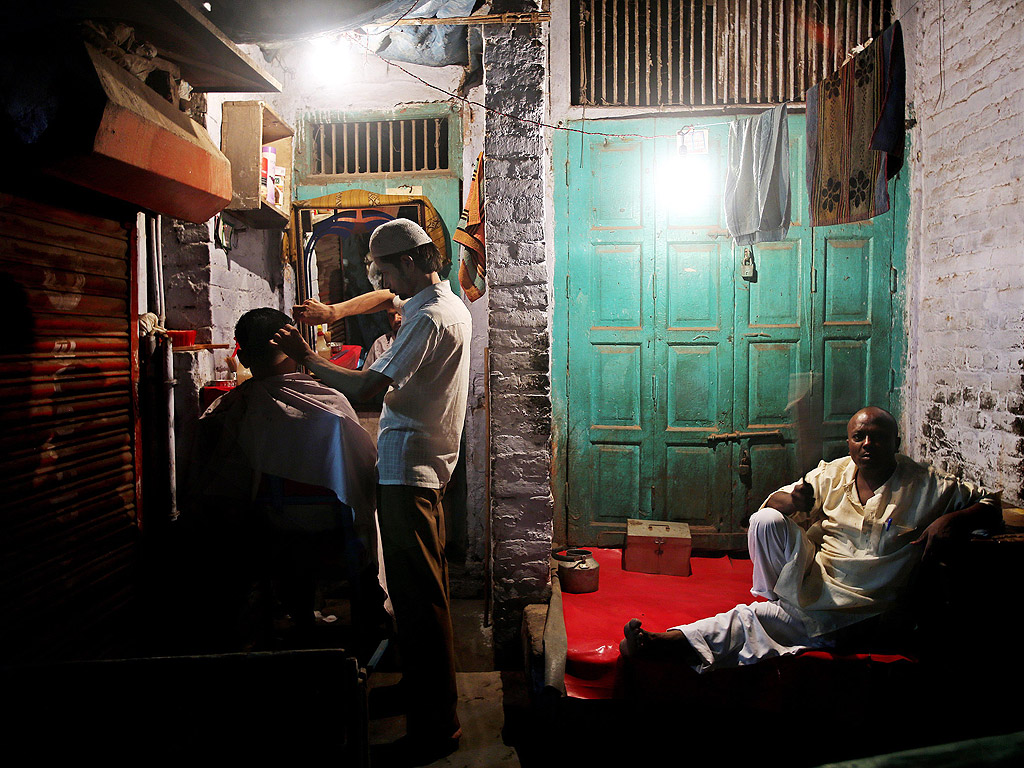 Индийски мюсюлманин посещава бръснарница в в навечерието на Рамазан Байрама, с който свършват едномесечния пост на мюсюлманите.